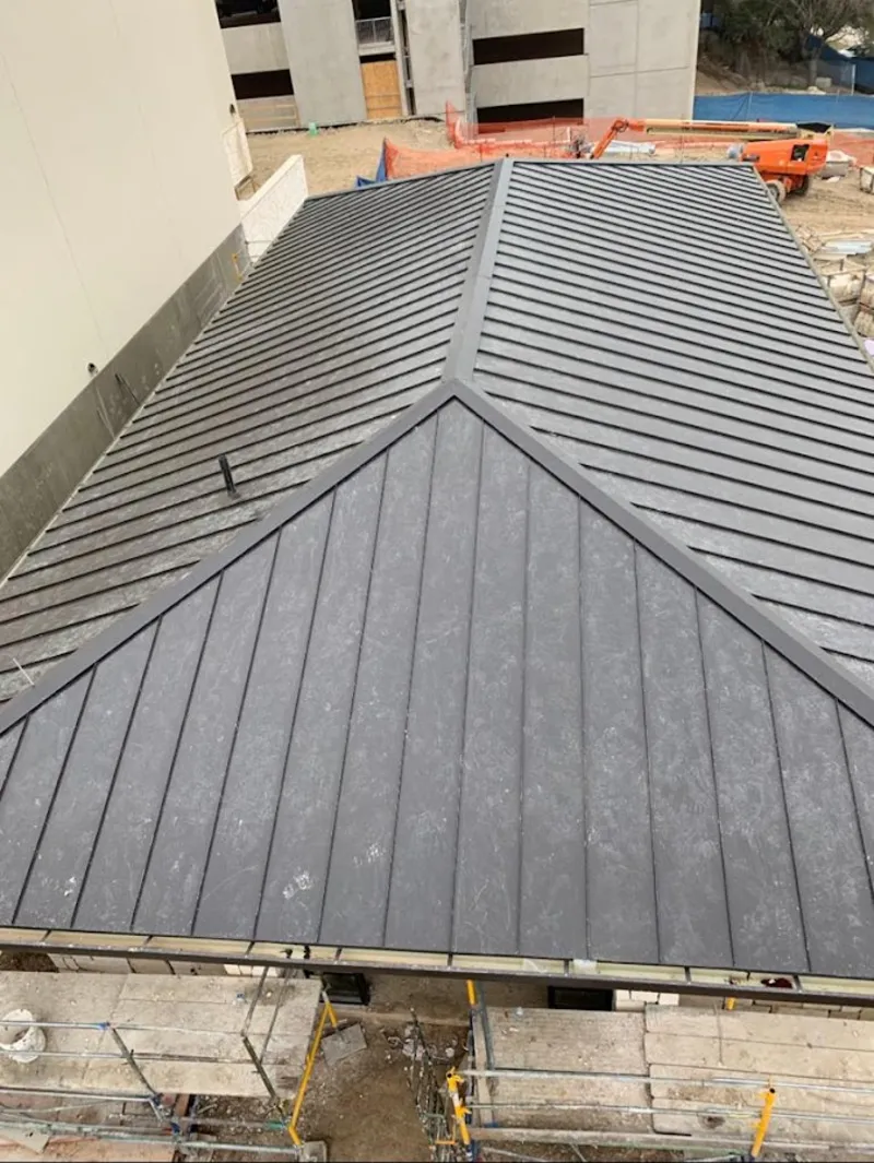 Commercial metal roof construction with crane equipment in Forestbrook